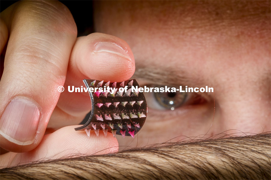 Graduate student Jordan Rosenbohm holds a flexible prototype for a smart bandage with tiny 3-D printed dagger-like needles. The clusters of needles are connected to channels that would deliver the medicine via an external pump. A new smart bandage design could eventually heal chronic wounds by getting under a patient’s skin — where an array tiny needles would deliver therapeutic drugs to the still-living but damaged tissue that needs them. Ali Tamayol and Ruiguo Yang authored the study with Nebraska’s Seth Harris, Craig Kreikemeier-Bower, Fariba Aghabaglou, Azadeh Mostafavi, Ian Ghanavati and Jordan Rosenbohm; Nebraska alumni Hossein Derakhshandeh, Alec McCarthy, Chris Wiseman and Zack Bonick; Harvard Medical School’s Dennis Orgill and Pooria Mostafalu; and Seyed Masoud Moosavi Basri of Shahid Beheshti University. February 26, 2020. Photo by Craig Chandler / University Communication.