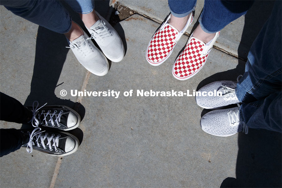 Harper Dining Center photo shoot. Students feet with fancy red and white checked Vans shoes. March 3, 2020. Photo by Craig Chandler / University Communication.