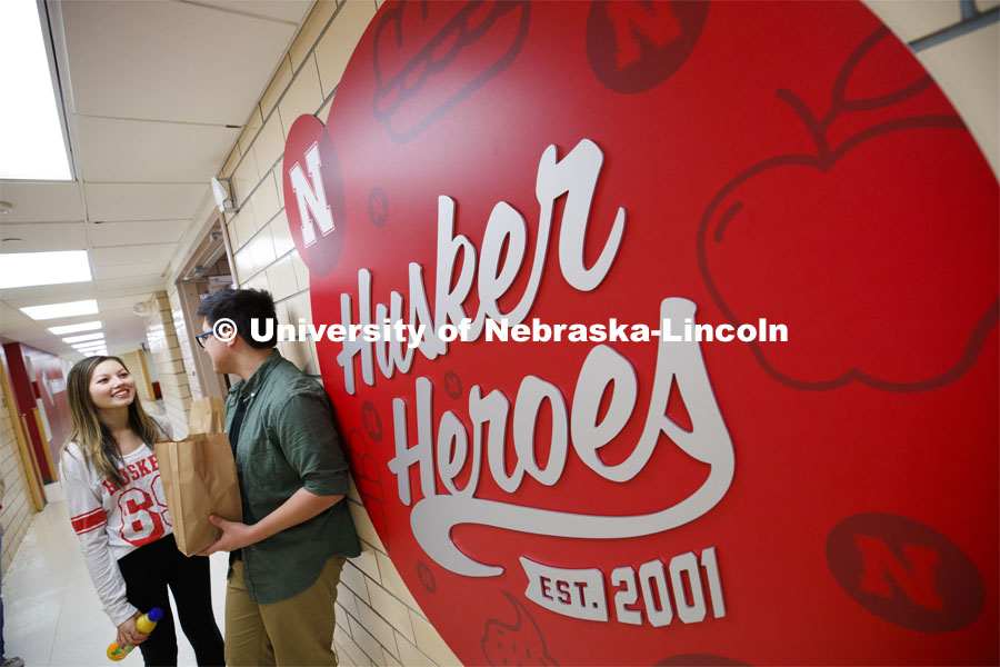 Selleck Dining Center photo shoot. Students standing next to the Husker Heroes logo in Selleck Dining Center. March 5, 2020. Photo by Craig Chandler / University Communication.