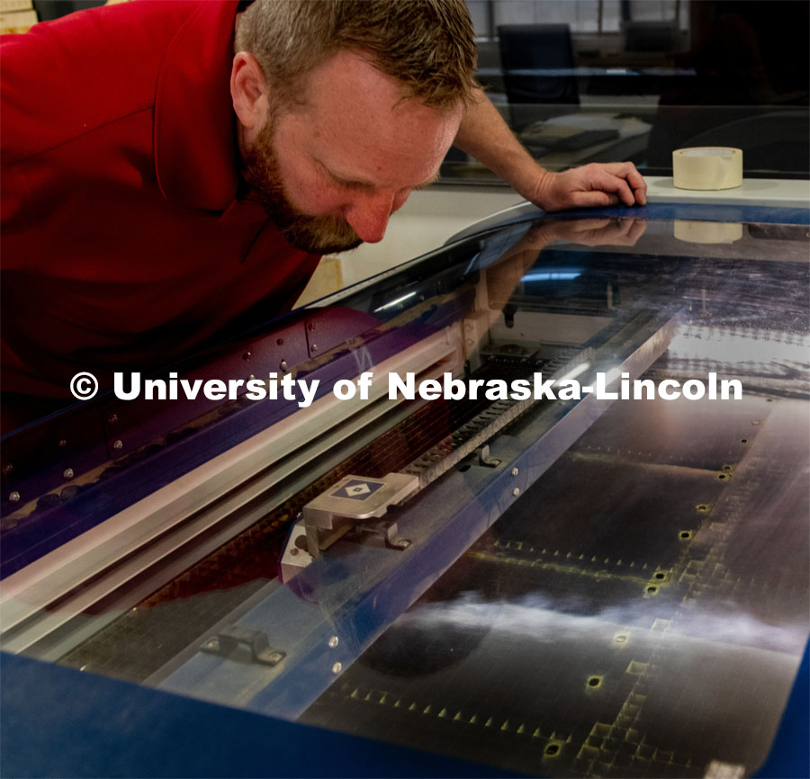 Jerry Reif, shop manager at Nebraska Innovation Studio, works on a laser to cut clear plastic sheeting for face shields. The face shields are being assembled for hospitals in Nebraska in response to COVID-19. April 1, 2020. Photo by Gregory Nathan / University Communication.