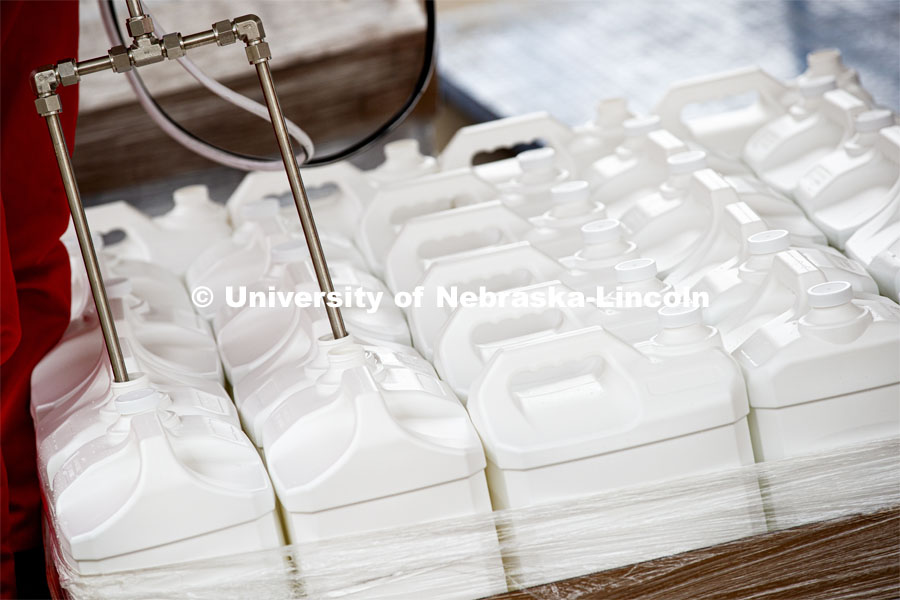Jugs are filled two at a time with hand sanitizer is being made at Nebraska Innovation Campus thanks to a collaboration between the Food Innovation Center and the Nebraska Ethanol Board. April 6, 2020. Photo by Craig Chandler / University Communication.