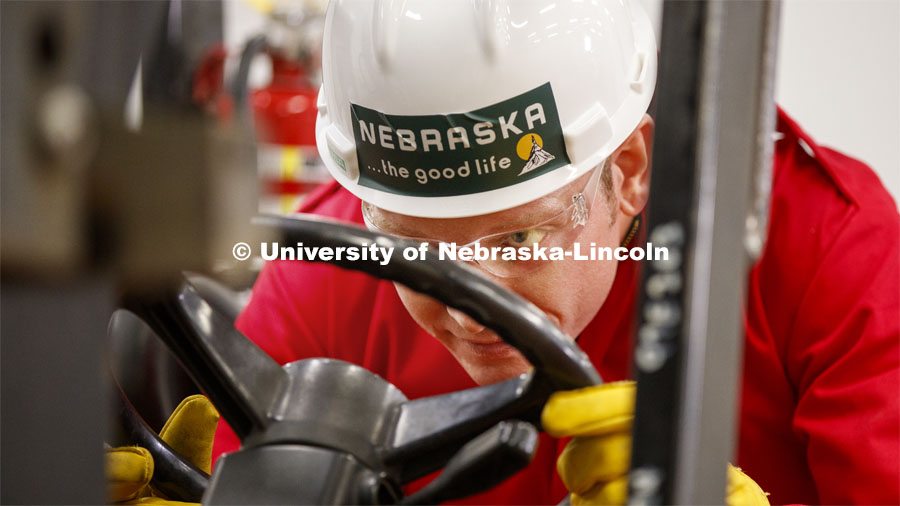 Russell Parde peers under the pallet of non-flammable ingredients as he steers it into place inside Food Innovation Center. The ingredients will be mixed with the ethanol in an outdoor area under stringent safety rules. Hand sanitizer is being made at Nebraska Innovation Campus thanks to a collaboration between the Food Innovation Center and the Nebraska Ethanol Board. April 6, 2020. Photo by Craig Chandler / University Communication.