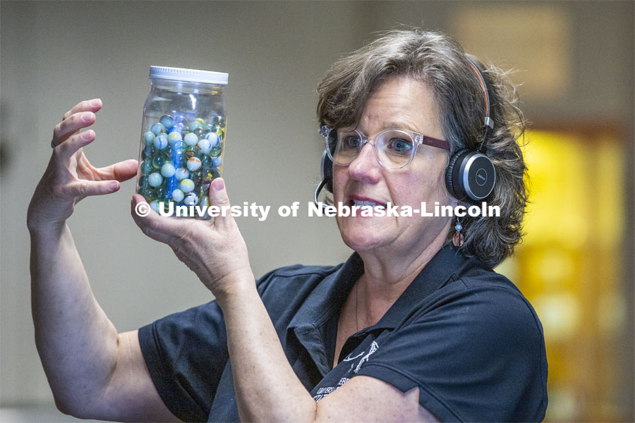 Annie Mumgaard, Virtual Learning Coordinator for the University Museum, uses a jar full of marbles to describe how individual rocks, like the marbles, can then be transformed by heat and pressure into metamorphic rock. April 14, 2020. Photo by Craig Chandler / University Communication.