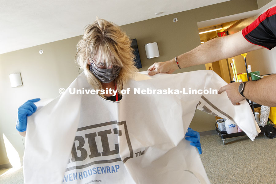 Cheryl Duncan, Residence Hall Custodial Leader with University Housing dons personal protective equipment  to demonstrate how the residence hall rooms will be cleaned. The face shields and Tyvek gowns were manufactured at Nebraska Innovation Campus. To enable first responders and medical personnel to self-isolate while still working, Harper Residence Hall will be used to house them.  Contractors are being trained to use PPE and safely clean the residence hall. The Nebraska National Guard will supervise the hall. April 17, 2020.