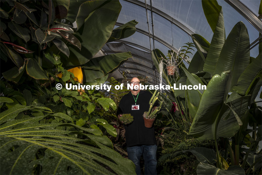 Jeff Witkowski, greenhouse manager for Agricultural Research Division, holds a couple of his favorite specimens in the East Campus “jungle.” The greenhouse, which is filled with tropical plants, a banana tree and succulents, is used as a teaching classroom. The facility, which is among greenhouses maintained by a team led by Witkowski, has been featured in remote teaching lessons through the end of the spring semester. April 23, 2020. Photo by Craig Chandler / University Communication.