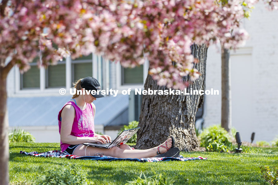 Kelsey Eihausen, sophomore from Bennington, studies outside of the Phi Mu sorority. She and other members staying in the chapter house study outside on a spring day. April 28, 2020. Photo by Craig Chandler / University Communication.