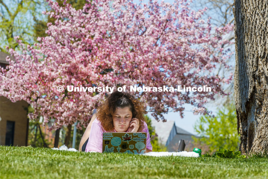 Molly Sambol, junior from Omaha, Zooms in on her learning and teaching language arts course outside of the Phi Mu sorority as she and other members staying in the chapter house study outside on a spring day. April 28, 2020. Photo by Craig Chandler / University Communication.