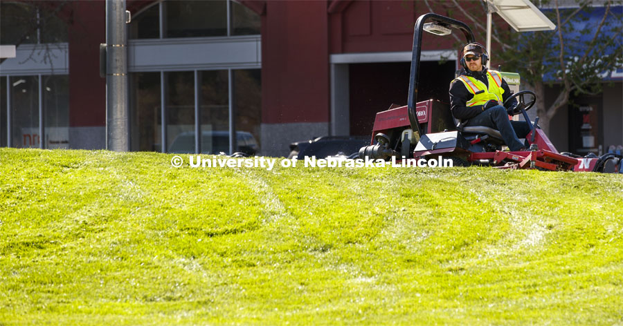 Tyler Kingsley, a worker with FM&P Landscape Services, mows outside the Visitors Center on 12th and Q Streets. May 5, 2020. Photo by Craig Chandler / University Communication.