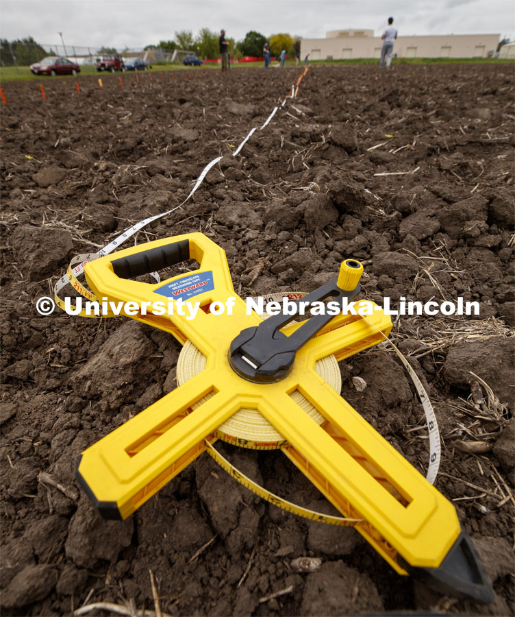 Tape measures are used to keep the row spacing accurate. James Schnable's group hand plants corn and sorghum seeds at the East Campus ag fields. May 20, 2020. Photo by Craig Chandler / University Communication.
