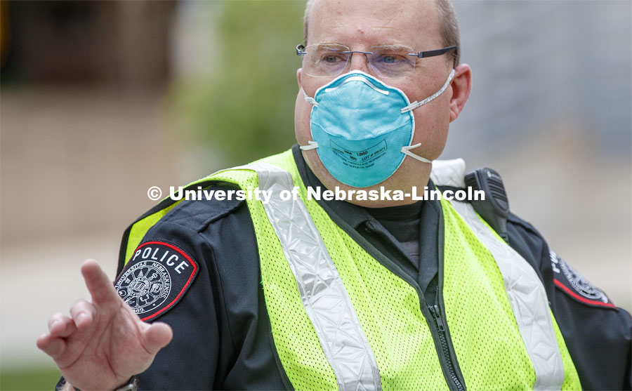 UNL Police Officer Paul Schmeling directs the huge traffic flow for people coming for the free flat of flowers left from the Horticulture Club Plant Sale. May 21, 2020. Photo by Craig Chandler / University Communication.
