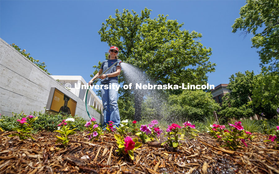 Karen Wilson with Landscape Services waters the flowers outside of the Sheldon Art Museum on City Campus. June 11, 2020. Photo by Craig Chandler / University Communication.