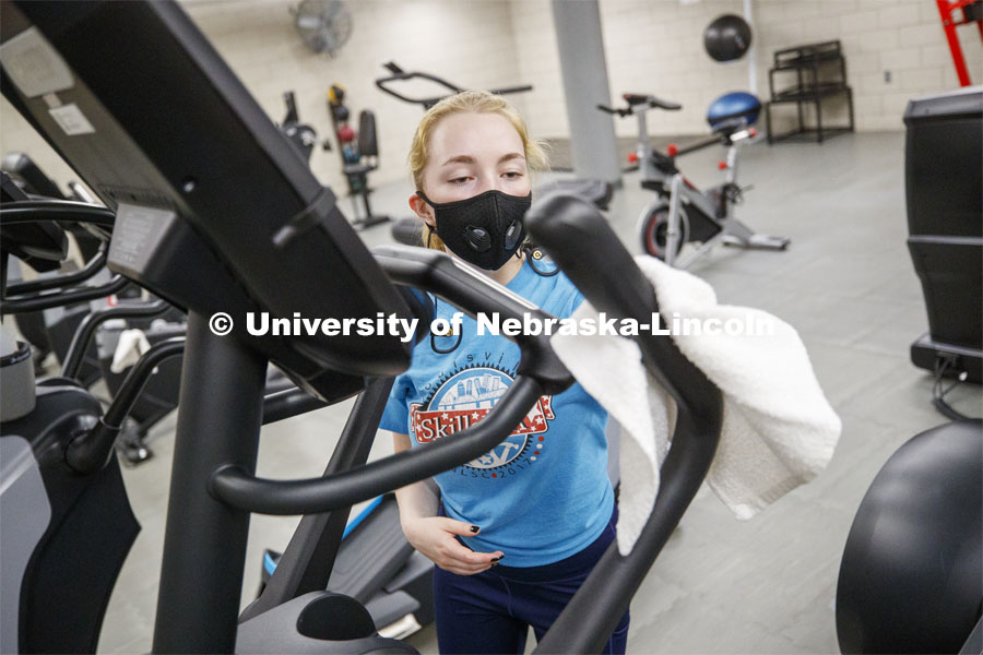 Ellenor Sell disinfects the elliptical after working out on the first day of Campus Recreation re-opening after being shut down due to COVID-19 concerns. June 15, 2020. Photo by Craig Chandler / University Communication.
