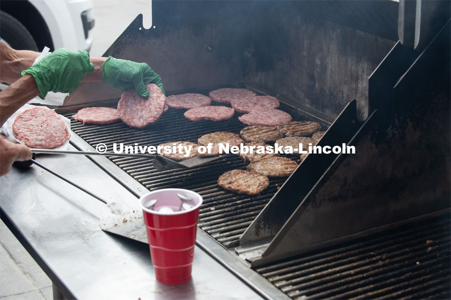 A grill full of pork burgers gets cooked up for the Lincoln City Mission. The pork, donated by pig farmer and University of Nebraska–Lincoln animal science alumnus, Bill Luckey, was the result of generosity, ingenuity, collaboration and a spirit of Nebraskans helping Nebraskans among the state’s pork producers, the Food Bank of Lincoln and the University of Nebraska–Lincoln. June 18, 2020. Photo by Gregory Nathan / University Communication.