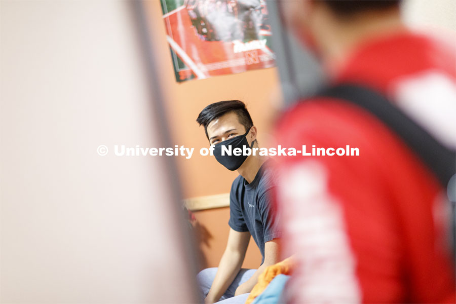 Photo shoot of students wearing masks and practicing social distancing in a University Suites Residence Hall room. June 24, 2020. Photo by Craig Chandler / University Communication.