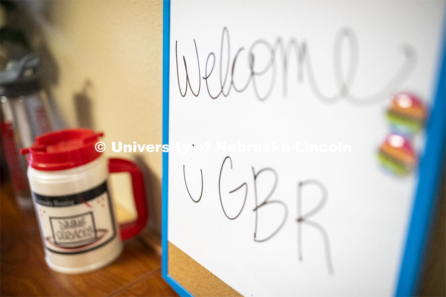 White marker board with “Welcome Go Big Red” written on it. Photo shoot of students wearing masks and practicing social distancing. June 24, 2020. Photo by Craig Chandler / University Communication.