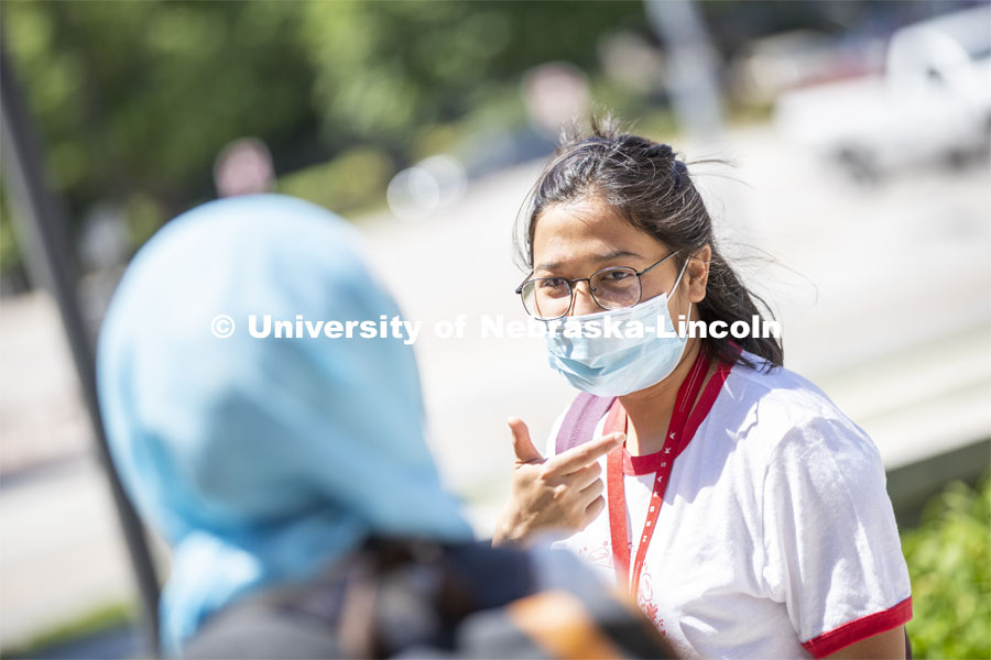 Sandhya Karki wears a mask while talking with a friend. Photo shoot of students wearing masks and practicing social distancing. June 24, 2020. Photo by Craig Chandler / University Communication.