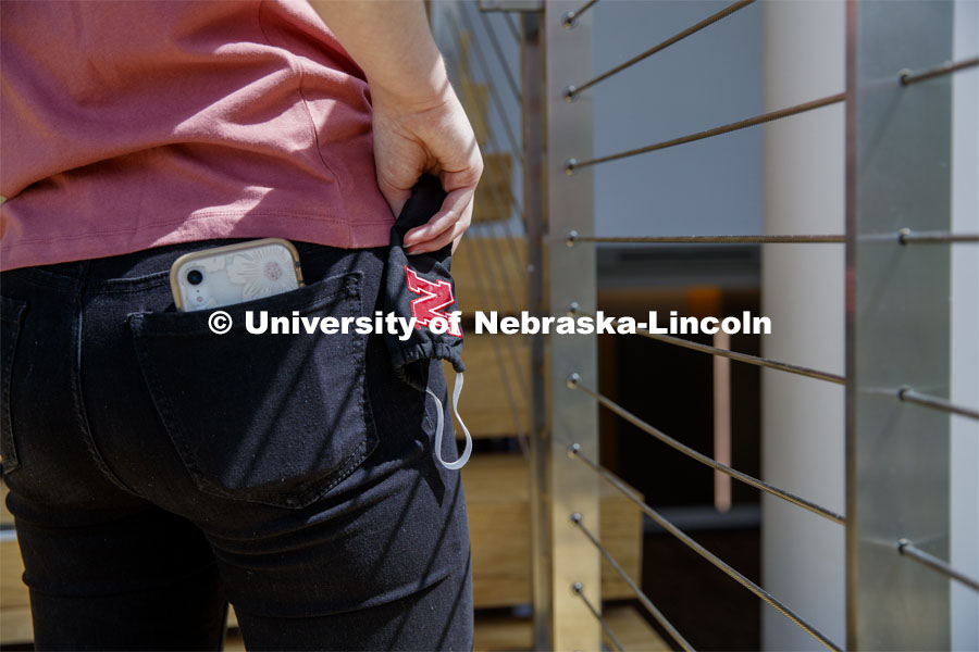 A student has their cell phone in back pants pocket and their Husker mask. Photo shoot of students wearing masks and practicing social distancing in dining services in Willa Cather Dining Center. July 1, 2020. Photo by Craig Chandler / University Communication.