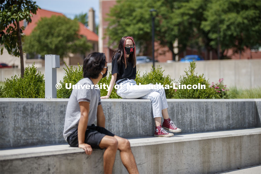 Students socialize outside the Willa Cather Dining Complex. Photo shoot of students wearing masks and practicing social distancing in dining services in Willa Cather Dining Center. July 1, 2020. Photo by Craig Chandler / University Communication.