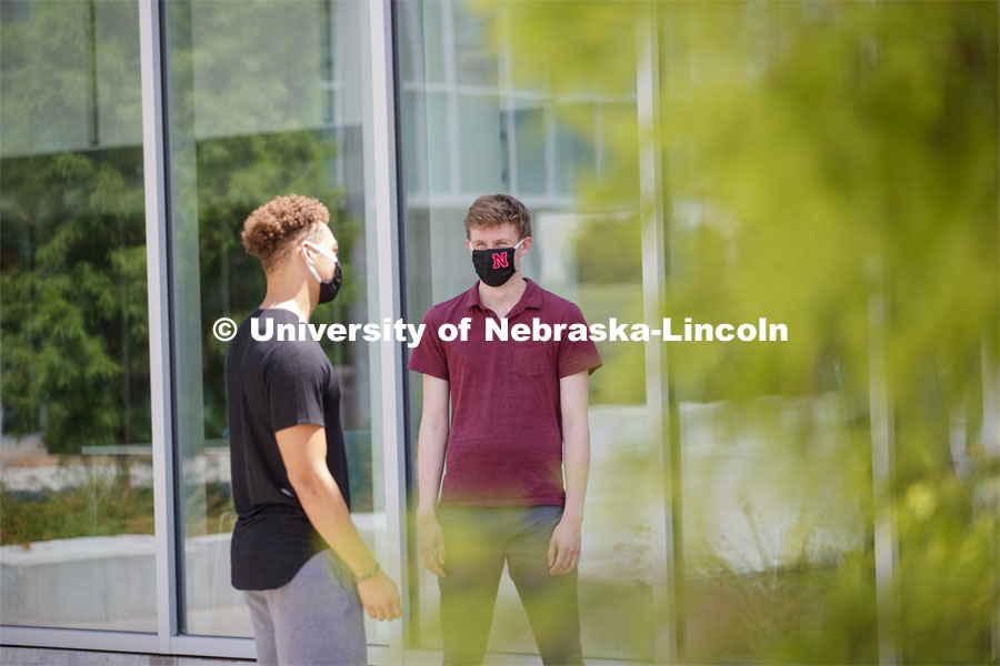 Students socialize outside the Willa Cather Dining Complex. Photo shoot of students wearing masks and practicing social distancing in dining services in Willa Cather Dining Center. July 1, 2020. Photo by Craig Chandler / University Communication.