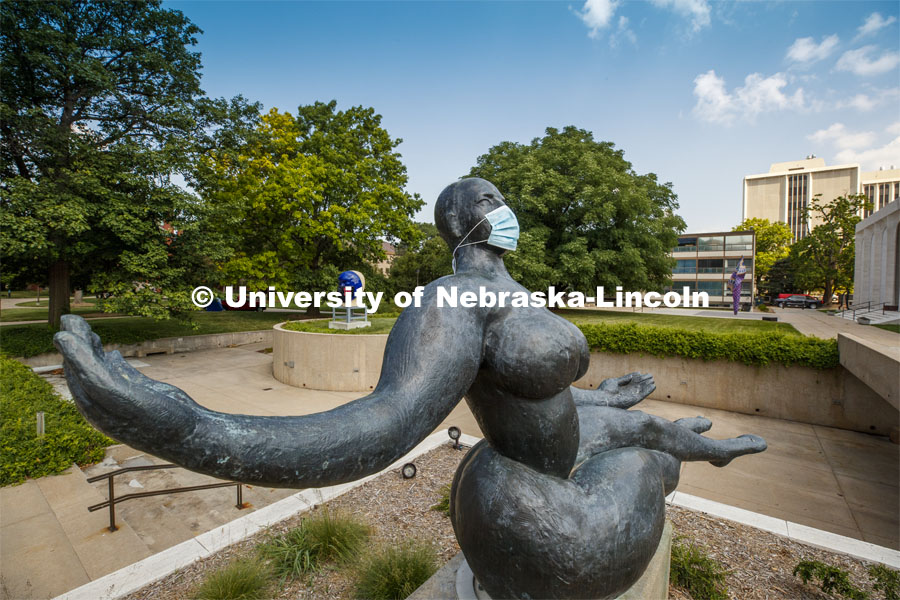 Floating Figure, a sculpture by Gaston Lachaise, is one of many UNL campus sculptures wearing masks. In the background is Untitled by Jun Kaneko also wearing a mask. Mask wearing statues on campus. July 6, 2020. Photo by Craig Chandler / University Communication.