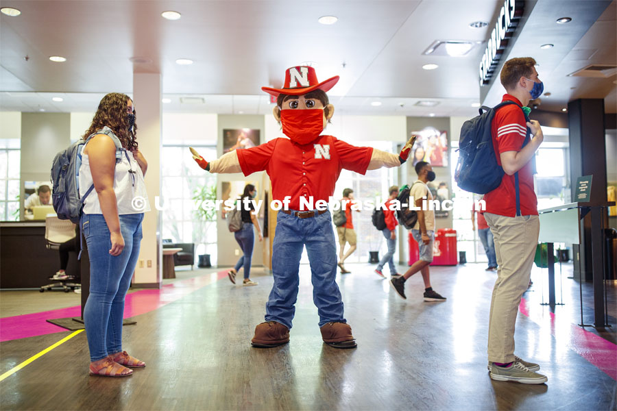 Photo shoot of students with Herbie on city campus display mask wearing, social distancing. Students stand in line to get coffee from Starbucks at the Nebraska Union. Herbie makes sure everyone is social distancing. August 5, 2020. Photo by Craig Chandler / University Communication.