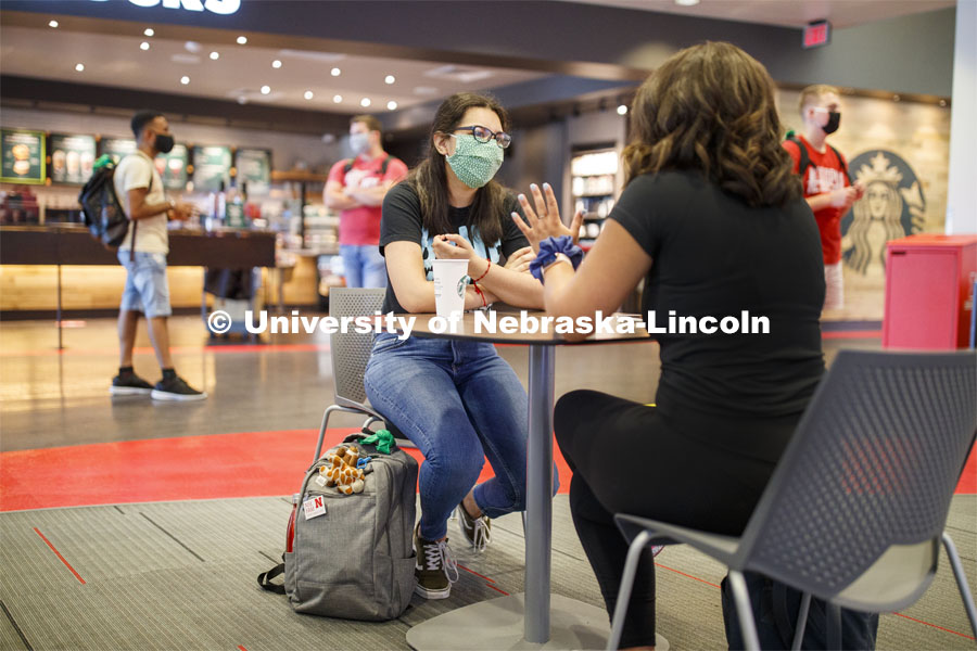 Photo shoot of students on city campus display mask wearing, social distancing. Students wearing masks while sitting together in the Nebraska Union. August 5, 2020. Photo by Craig Chandler / University Communication.