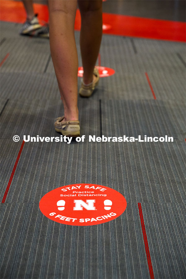 Social distancing stickers are placed on the floors to remind students to keep a distance of six feet apart. Photo shoot of students wearing masks and practicing social distancing. August 11, 2020 Photo by Craig Chandler / University Communication.