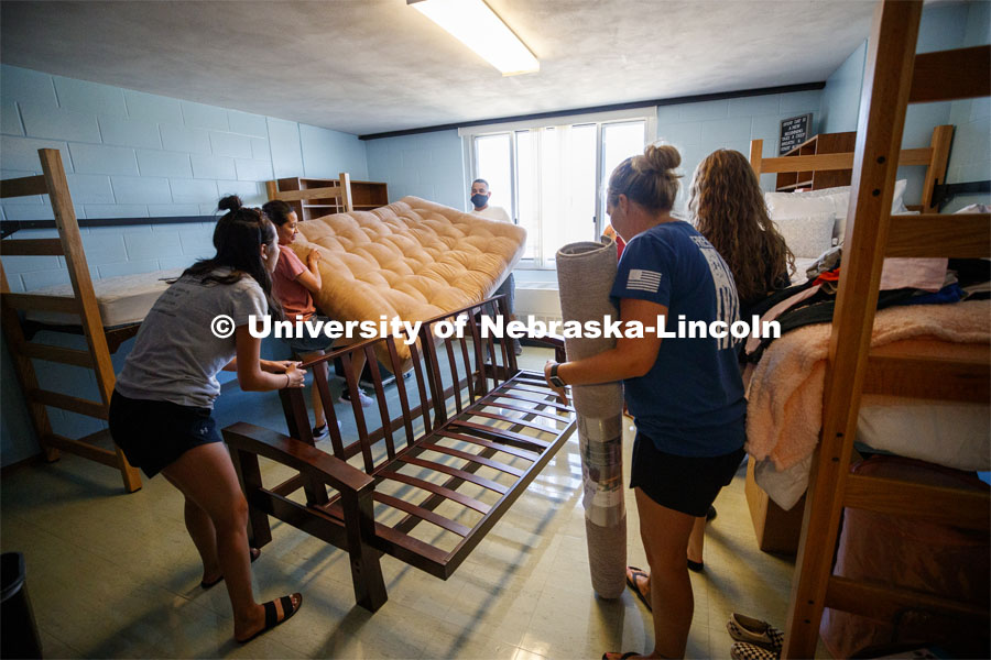 Shanelle Flores' family puts her futon together in her Harper Hall room. First day of residence hall move in. August 13, 2020. Photo by Craig Chandler / University Communication.