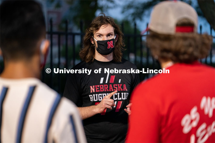 A member of the Nebraska Rugby Club (center) speaks to students during the HuskerMania Masker Singer event at Mabel Lee Fields. August 21, 2020. Photo by Jordan Opp for University Communication.