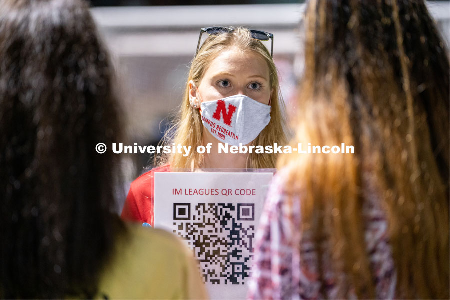 An employee of Nebraska Campus Recreation (center) speaks to students and holds up a QR code for them to scan during the HuskerMania Masker Singer event at Mabel Lee Fields. August 21, 2020. Photo by Jordan Opp for University Communication.