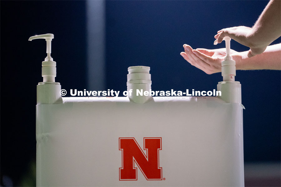 A student makes use of a hand sanitizing station while leaving Mabel Lee Fields at the conclusion of the HuskerMania Masker Singer event. August 21, 2020. Photo by Jordan Opp for University Communication.