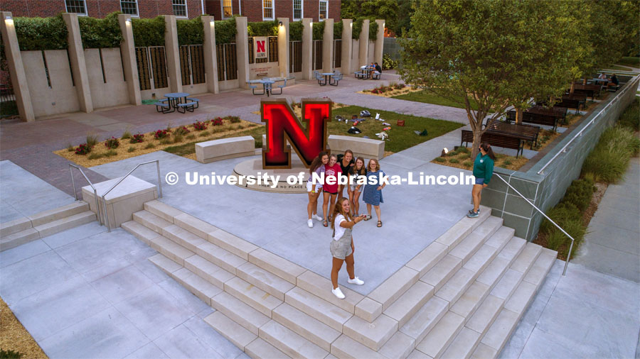 A group of young ladies take a selfie in front of Alumni Association's N Sculpture in the newly renovated Holling Garden. August 24, 2020. Photo by Craig Chandler / University Communication.