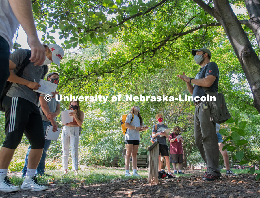 Students listen as Professor Eric North describes what feature to observe to identify this magnolia tree. First day of in-person learning for the fall semester. August 24, 2020. Photo by Gregory Nathan / University Communication.
