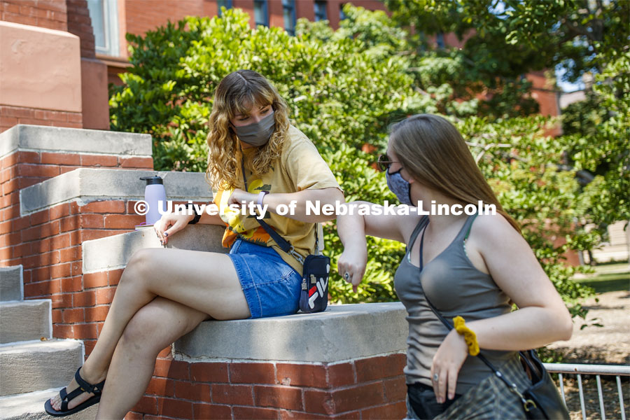 Ciara Allen elbow bumps Frannie Folsom while they wait for their afternoon architecture class to begin. First day for in-person learning for the fall semester. August 24, 2020. Photo by Craig Chandler / University Communication.
