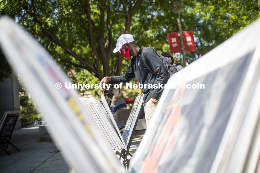 Mohamed Komi looks over posters for sale in front of the Nebraska Union Monday. City Campus. August 31, 2020. Photo by Craig Chandler / University Communication.