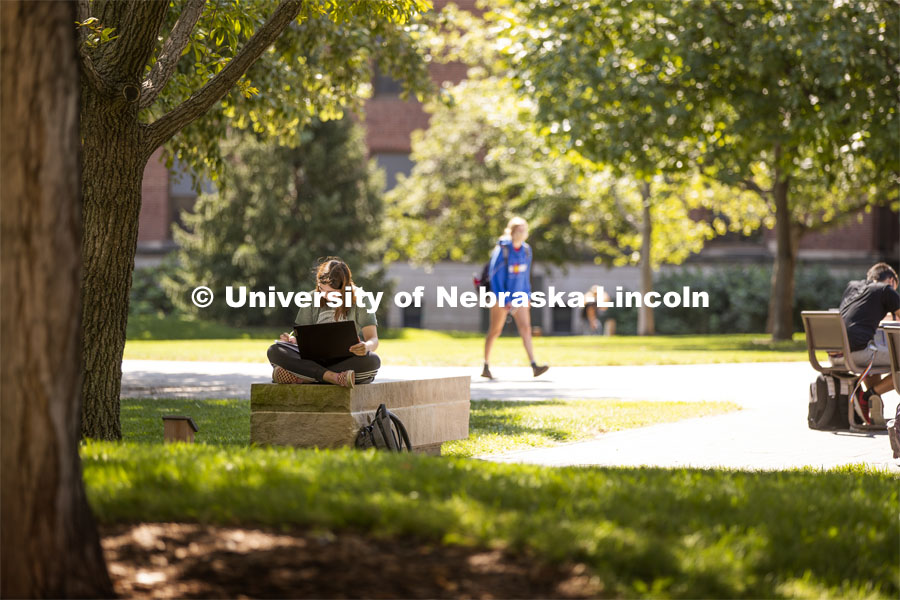Isabella Kane zooms her class from a shady bench outside of Love Library's Adele Coryell Hall Learning Commons. City Campus. August 31, 2020. Photo by Craig Chandler / University Communication.