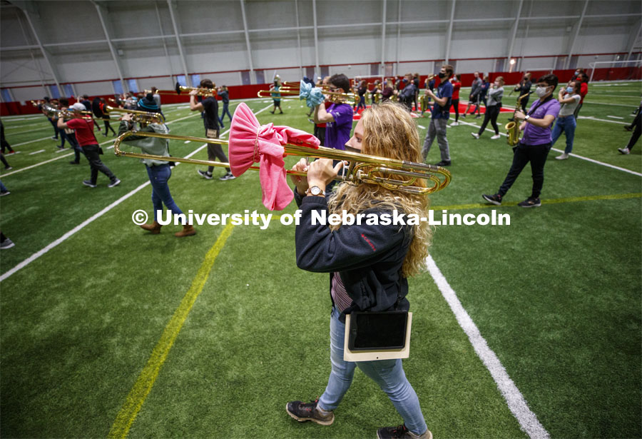 Regan Hennings practices marching as both she and her trombone are properly covered. One third of the marching band meets each morning at Cook to practice as the rest of the band practices in other locations where they can properly distance. Cornhusker Marching Band practice in Cook Pavilion. September 10, 2020. Photo by Craig Chandler / University Communication.