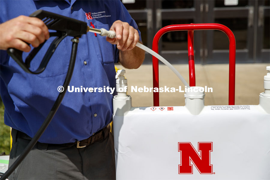 Brent Clabaugh, Zone Preventive Maint Associate with Facilities, refills a large sanitizer dispenser back into Hamilton Hall. The large dispensers are refilled outdoors for safety reasons. September 15, 2020. Photo by Craig Chandler / University Communication