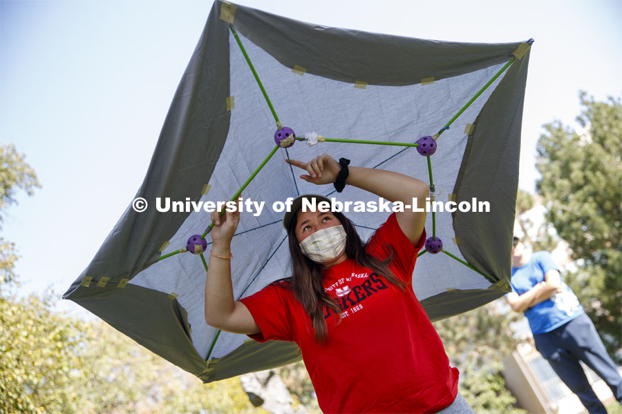 Makena Ninete describes the structure of her hat and shelter. Sharon Kuska's ARCH 231 - Structural Fundamentals class had to build a structure that promotes social distancing using structural fundamentals and sustainable materials. September 22, 2020. Photo by Craig Chandler / University Communication.