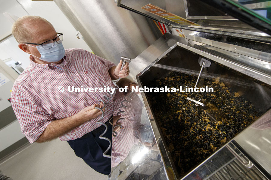 Dave Annis, Director of University Dining Service, sprays down the food and enzyme pellets in the biodigester in Cather Dining Center. The biodigester can hold up to 400 pounds of food and turn it into water within a day. September 23, 2020 Photo by Craig Chandler / University Communication.