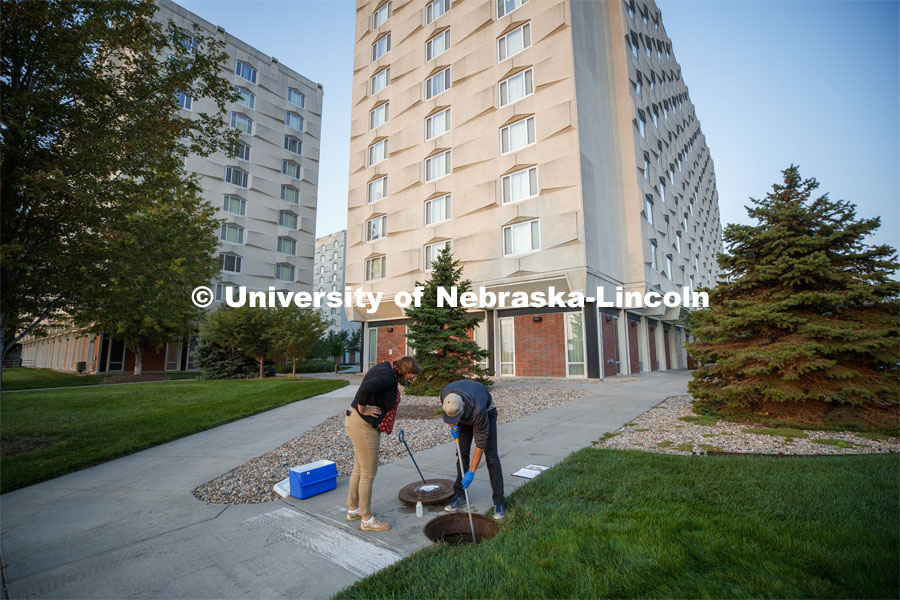 Shannon Bartelt-Hunt observes Spencer Perry, a graduate student in environmental engineering, take a wastewater sample from the sewer flowing from Harper Residence Hall. He and Bartelt-Hunt, professor in civil engineering, are sampling wastewater from UNL residence halls for COVID research. September 24, 2020. Photo by Craig Chandler / University Communication.