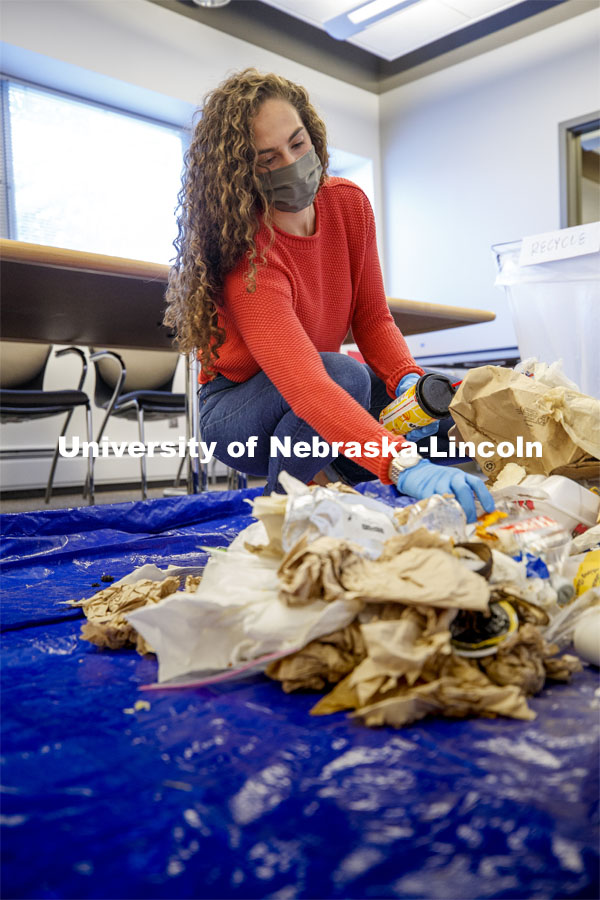 Morgan Hartman sorts waste in an Andersen Hall classroom. The waste audit was performed on trash saved by the custodians in Andersen Hall. After spreading out a tarp to sort the trash on, the bag is weighed and then dumped for sorting. Of the 11.9 pounds of trash in this bag, 38% was landfill material, 48% was compostable and 14% was recyclable. October 26, 2020. Photo by Craig Chandler / University Communication.
