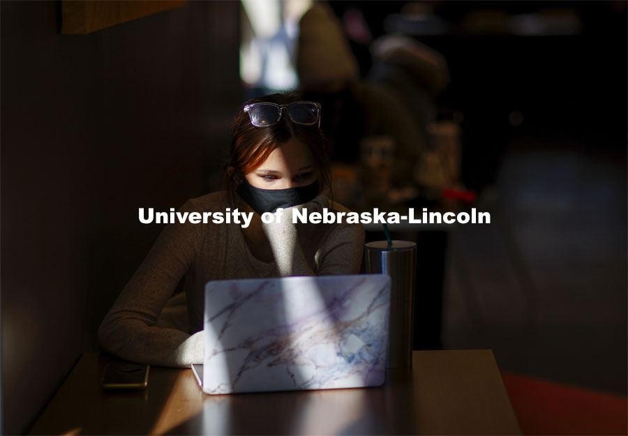 Emily Diesing, a sophomore from Omaha, studies in a ray of afternoon sunshine in the Nebraska Union. October 27, 2020. Photo by Craig Chandler / University Communication.