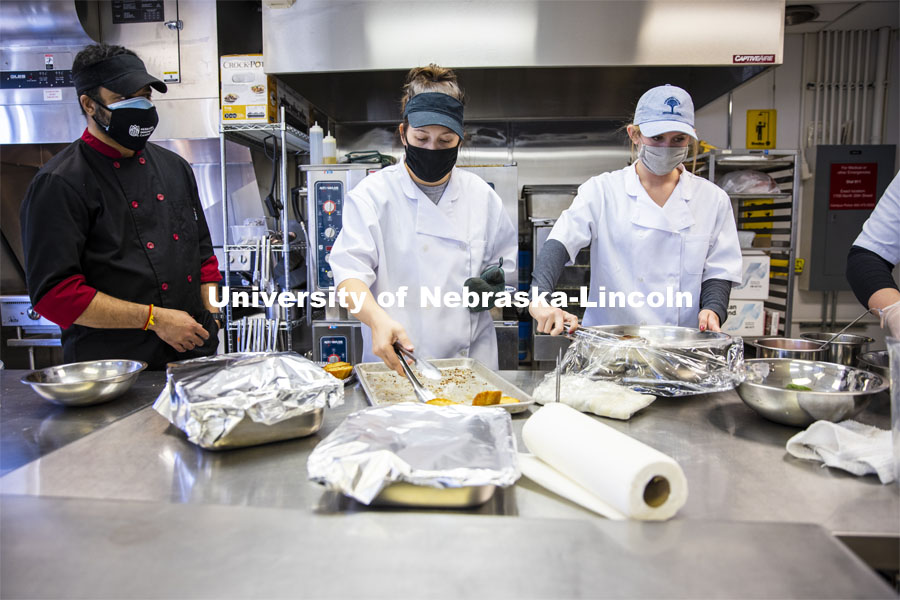 Professor Ajai Ammachathram’s, left, watches as his Catering Management students prepare a wedding feast as the final project for the semester. November 18, 2020. Photo by Craig Chandler / University Communication.