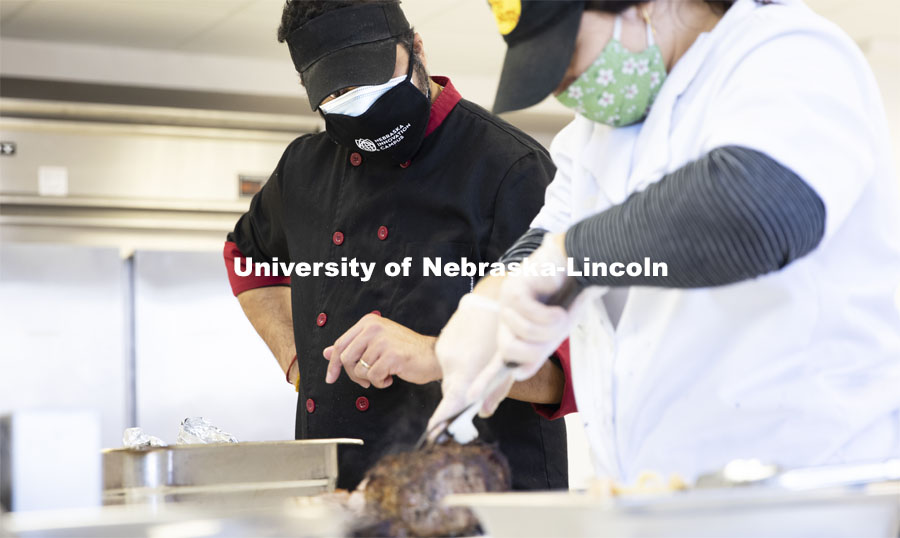 Professor Ajai Ammachathram oversees the carving of the prime rib as his Catering Management students prepare a wedding feast as the final project for the semester. November 18, 2020. Photo by Craig Chandler / University Communication.