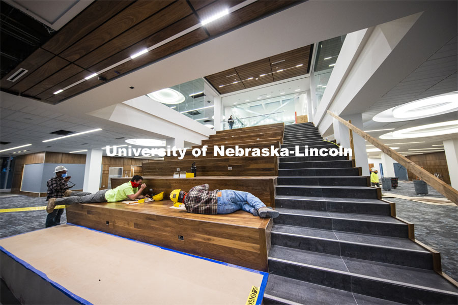 Workers wire electrical outlets into the Learning Stairs. The tiered area leading to the second floor will have cushions to sit on and will face a drop-down interactive screen. Tour of remodeled C.Y. Thompson Library on East Campus. November 23, 2020. Photo by Craig Chandler / University Communication.