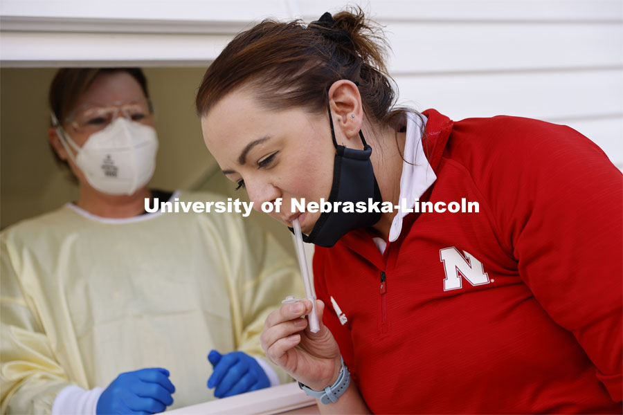 Jessica Calvi, a research assistant professor with the Nebraska Athletic Performance Lab, demonstrates the new saliva-based COVID test as Stephanie Padilla, R.N. watches. In the Spring, students, faculty and staff on campus will be using the test. December 2, 2020. Photo by Craig Chandler / University Communication.