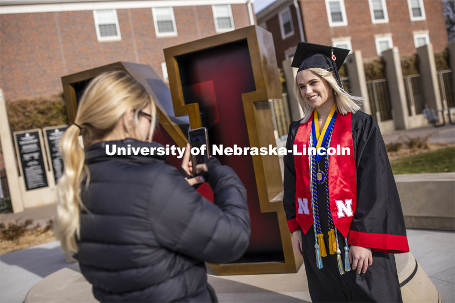Paige Heitkamp, a senior in Criminal Justice from Sioux Falls is photographed by Jessica Kistaitis in front of The Value of N sculpture at the alumni center. December 8, 2020. Photo by Craig Chandler / University Communication.