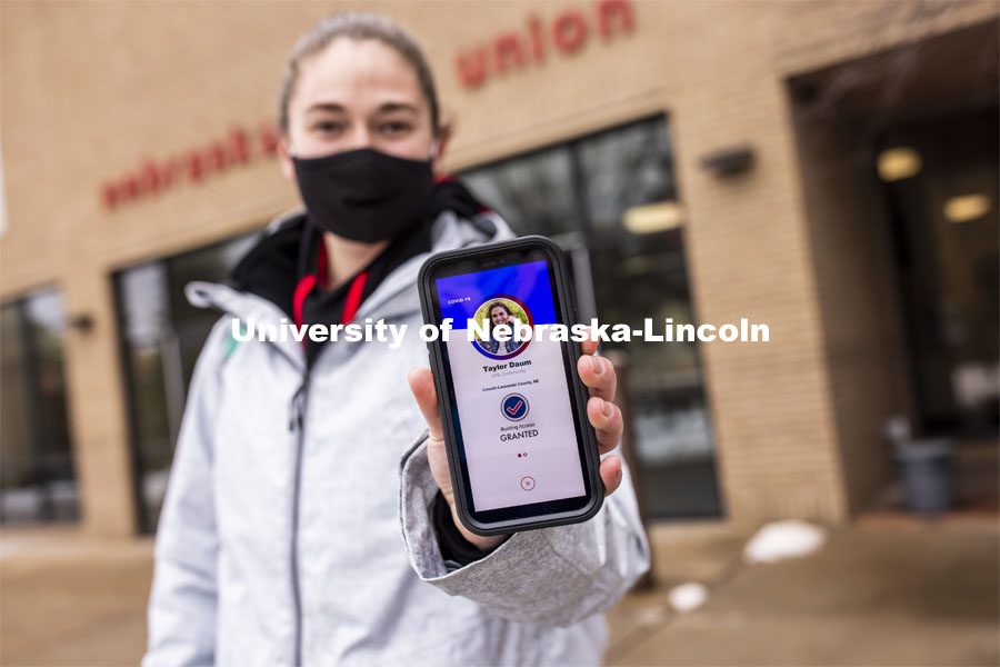 Taylor Daum shows the Safer Community app to be used as part of COVID testing on campus this spring. Phone screen is simulated and may change slightly in the final rollout. January 8, 2021. Photo by Craig Chandler / University Communication.