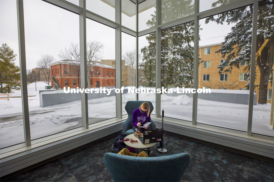 Lydia Cole, a senior from Plattsmouth, NE, studies in the corner seat ner the windows of the Dinsdale Family Learning Commons on East Campus. January 28, 2021. Photo by Craig Chandler / University Communication.